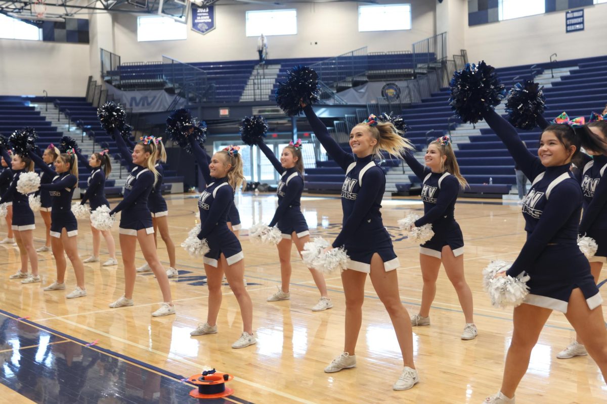 Arms out, the cheer team performs the fight song.