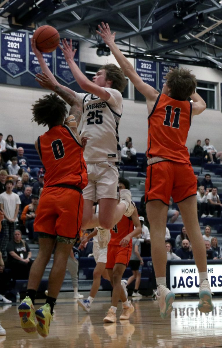 Pushing past his opponents, junior Carter Kaifes makes a layup. 