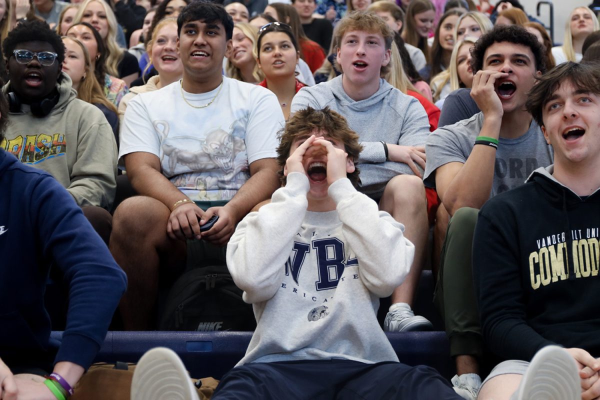 Leaning back, junior Jackson Fisher participates in traditions by yelling “Hey, hey, whaddya say?”