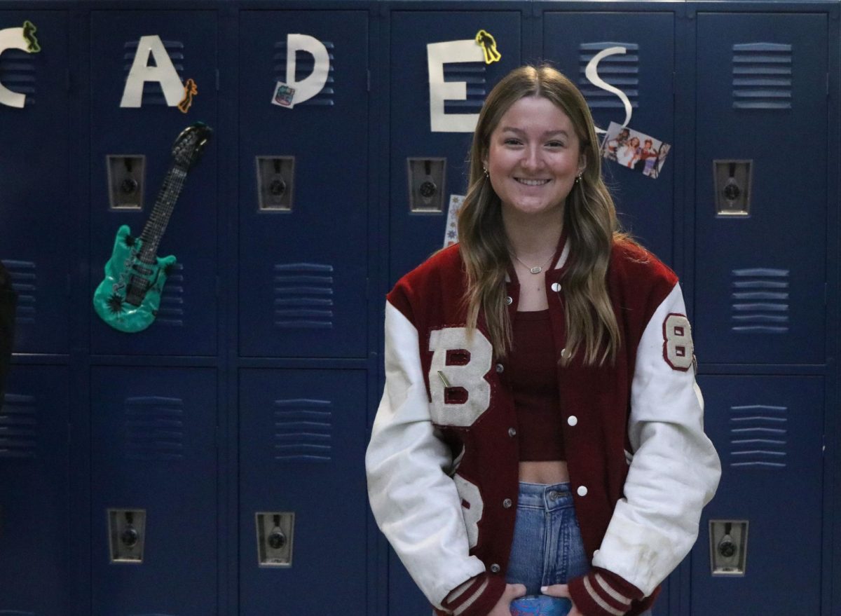 Standing in front of the decorations, sophomore Mallory Lux dresses up for decades day Thursday Feb. 1st