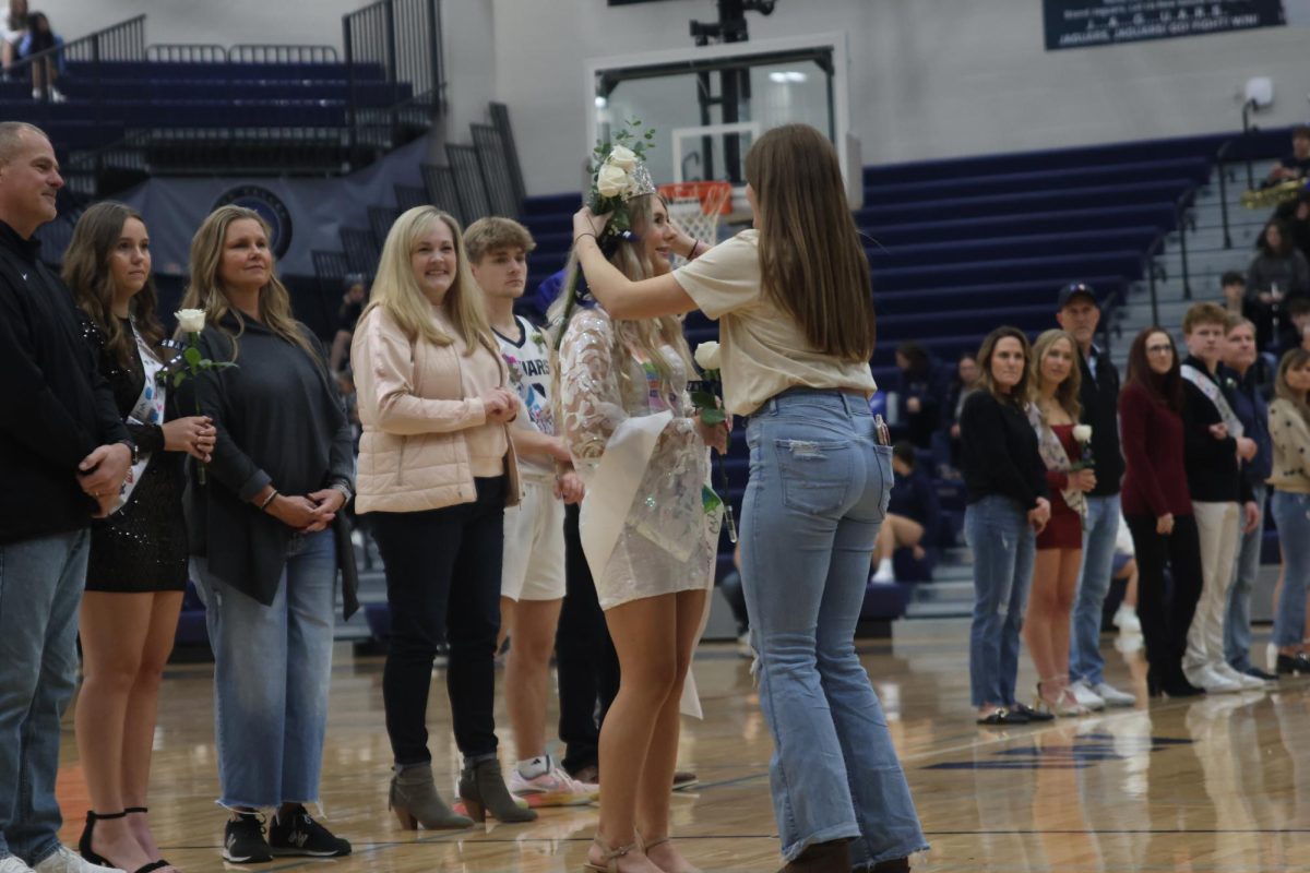 Senior Lucy Roy crowns senior Violet Hentages Winter Homecoming Queen.