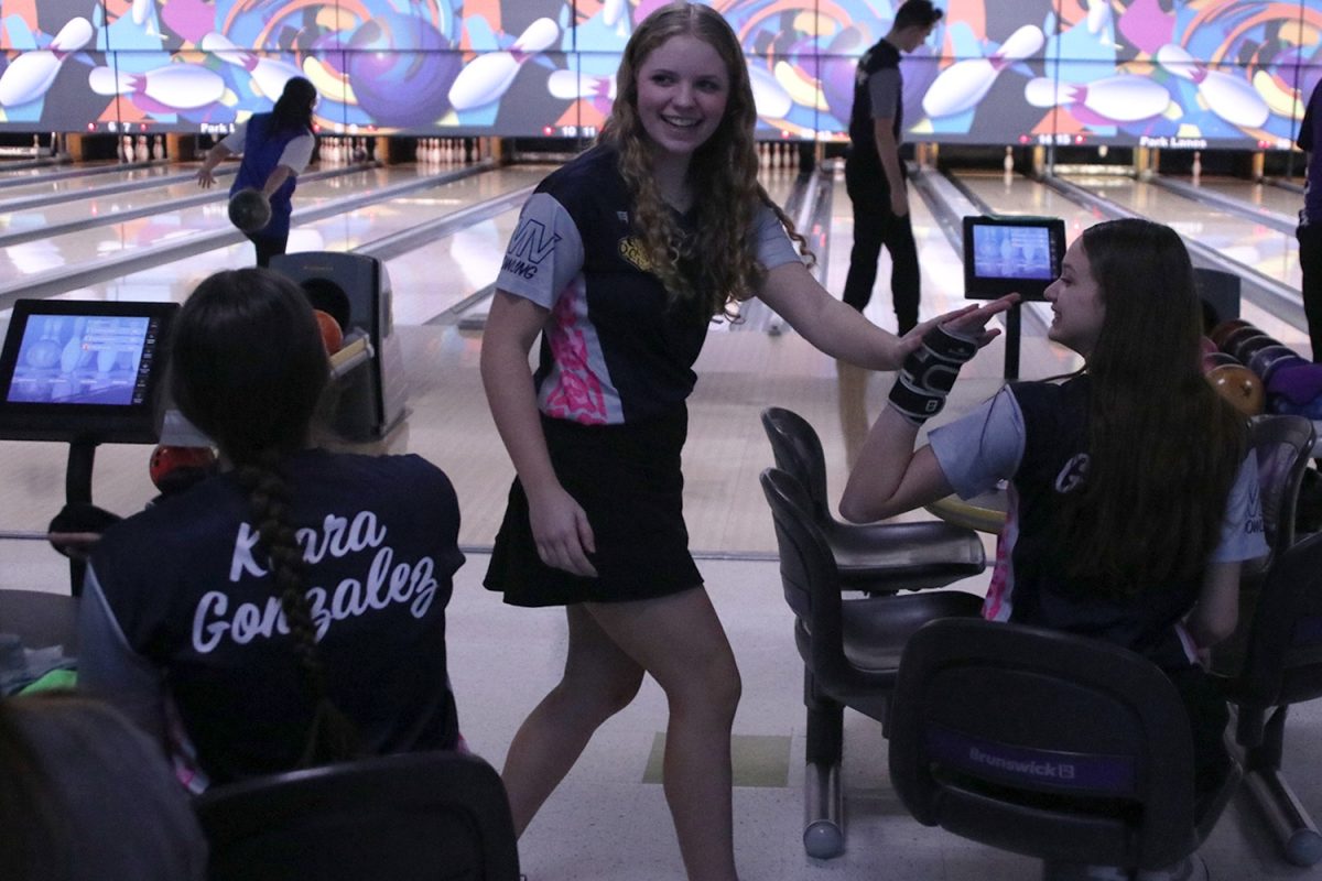 Celebrating a strike, sophomores Abby Haney and Layla Gonzalez high five at the bowling meet. Haney bowled a series of 470 earning her seventh place individually while Gonzalez bowled a series of 712 earning her first place individually.