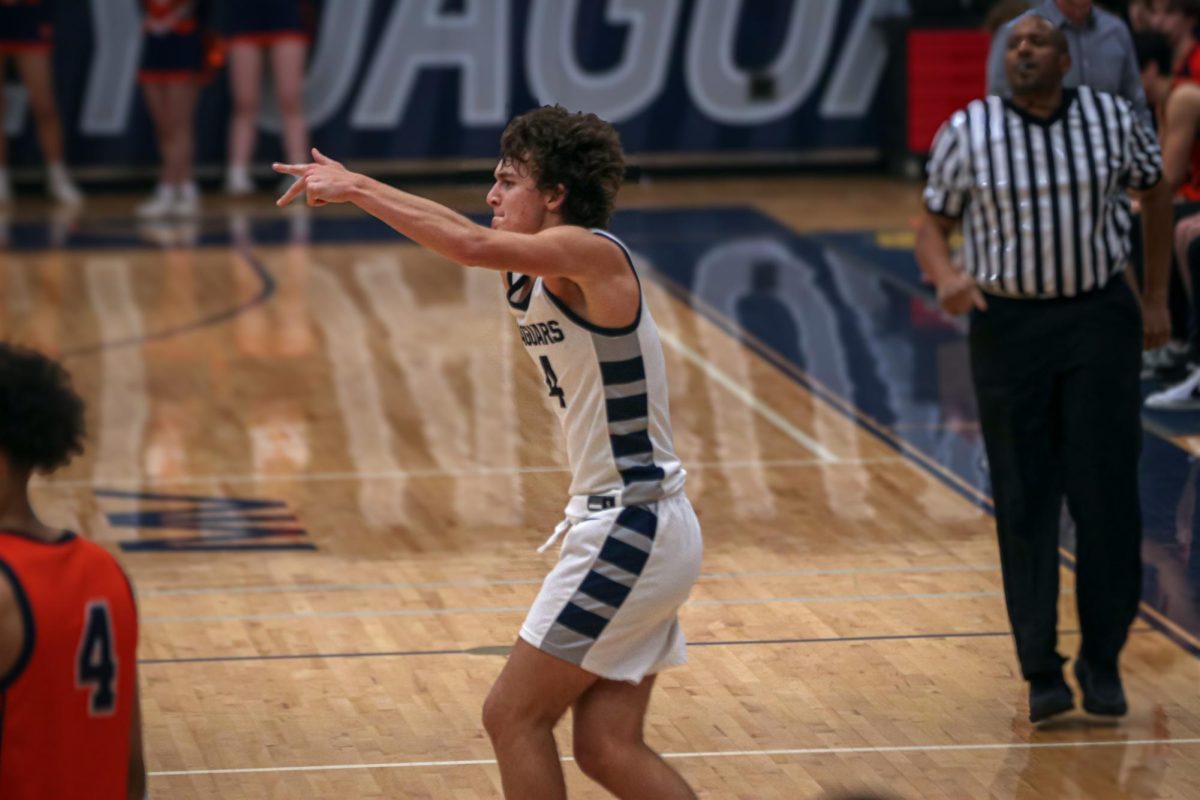 After making a three, sophomore Reece Riedel throws up 3 fingers in celebration.