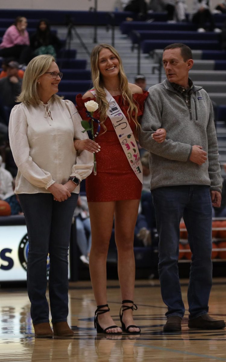 While being announced, winter homecoming Queen candidate Julia Coacher smiles towards the crowd.