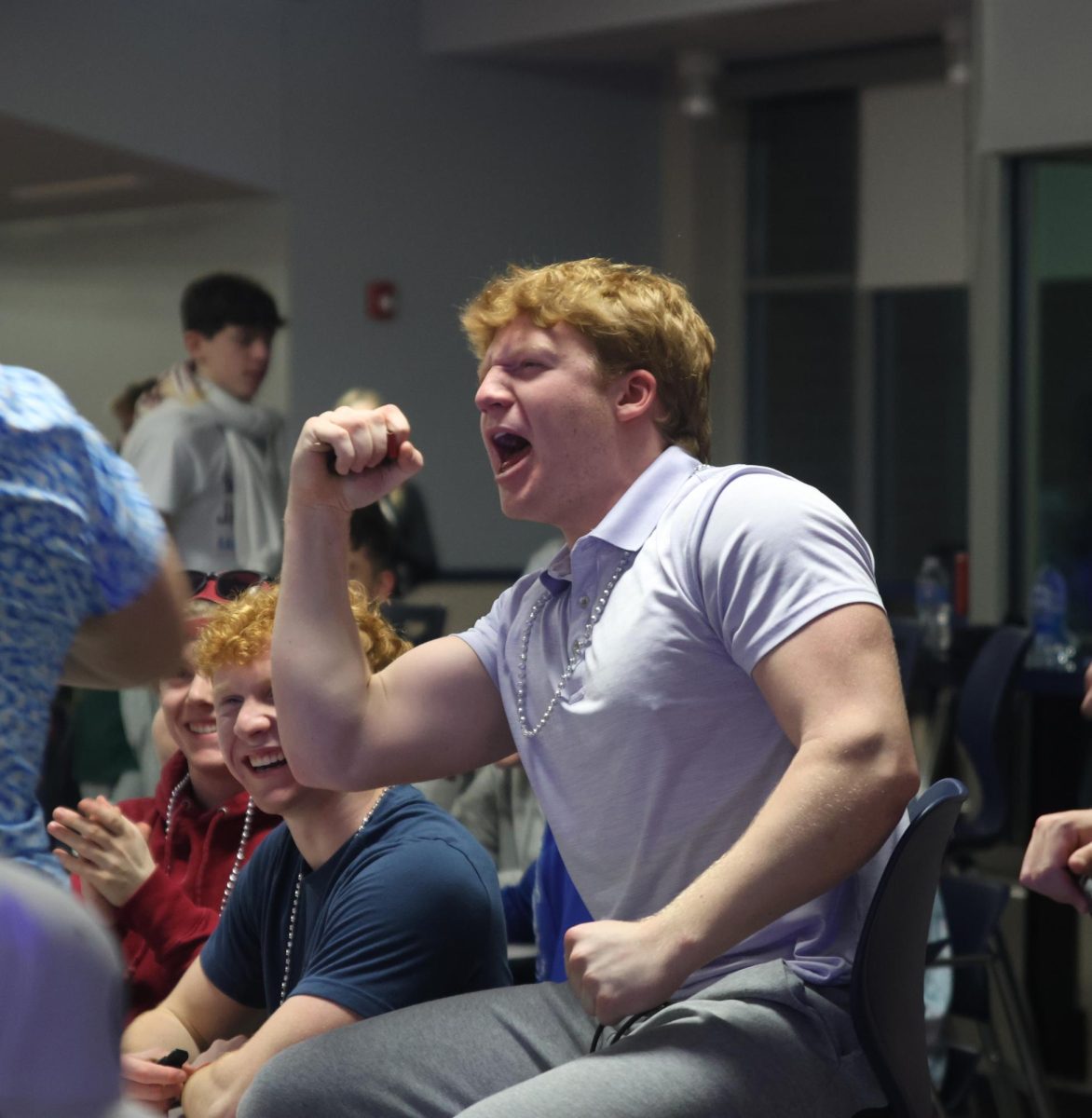 Balling his fist in the air, junior Conner Wood celebrates after him and his team gets a question right. 