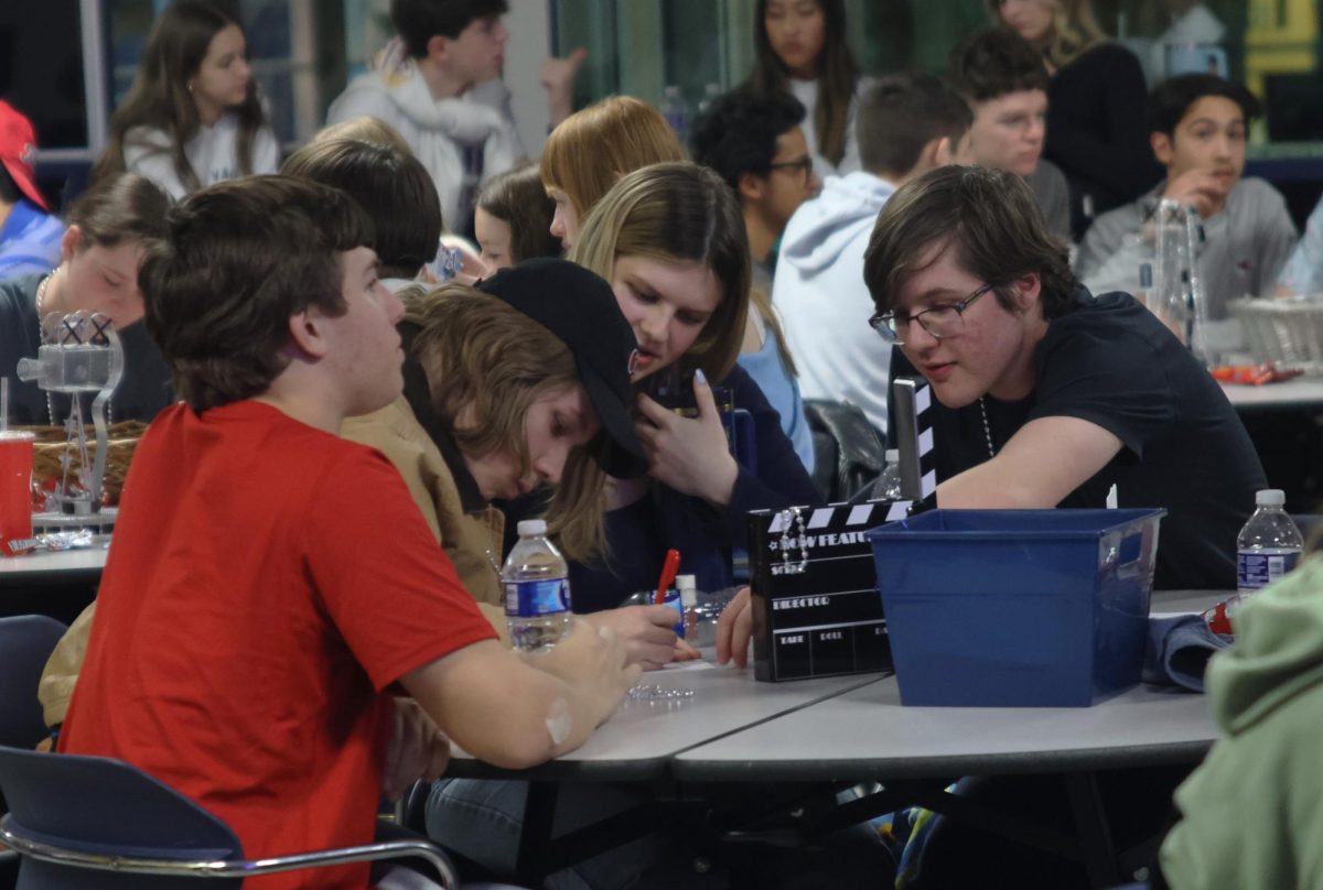 Sophomores Ian Weatherman, Jack Thomas, Andrew Heidenman and junior Abigail Gafney discuss as a group what the answer could be.