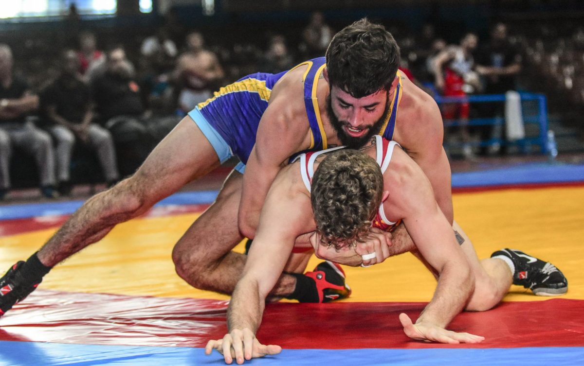 Holding his opponent down, head wrestling coach Joey Lazor focuses.