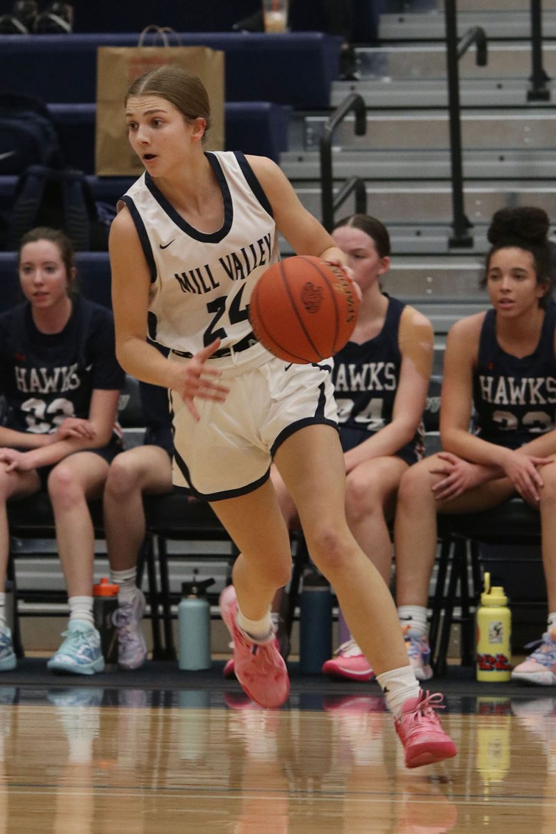 Running with the ball, junior Averie Landon looks for an open teammate.  