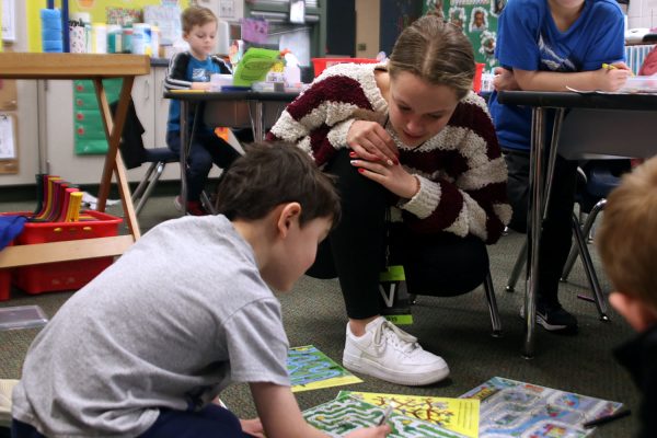In Mrs. Goetsch’s kindergarten classroom, senior Kaylen Hyde helps kids reach the end of their erasable mazes Friday, Feb. 2.