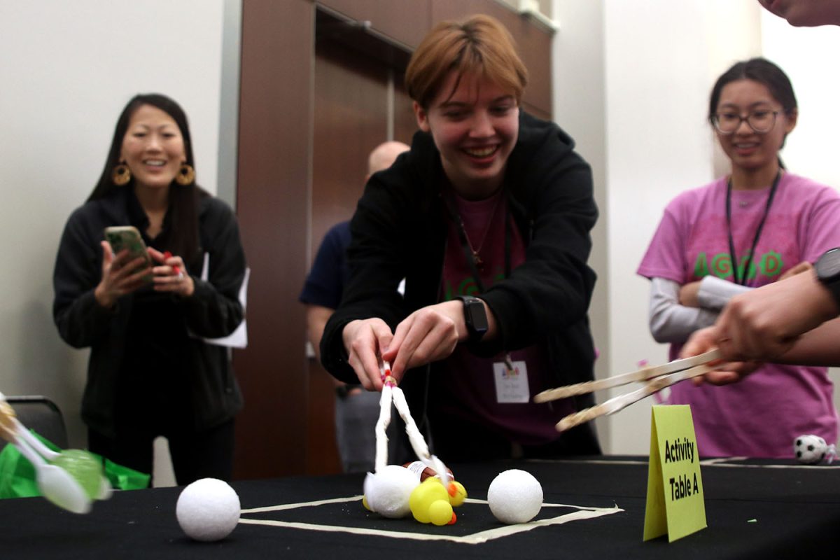 As the competition begins, junior Cora Jones uses an engineered grabber to pick up objects and bring them into the goal.