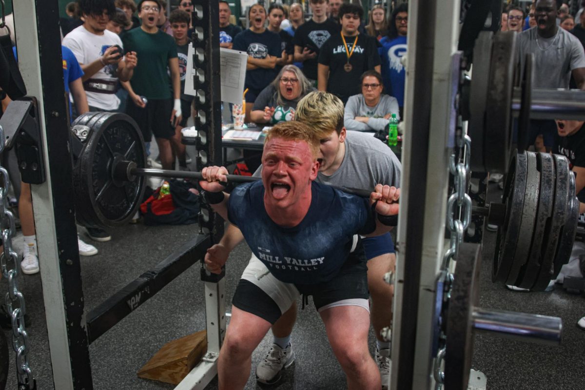 Encouraged by the crowd, senior Waylon Schenk squats during power-lifting state.  