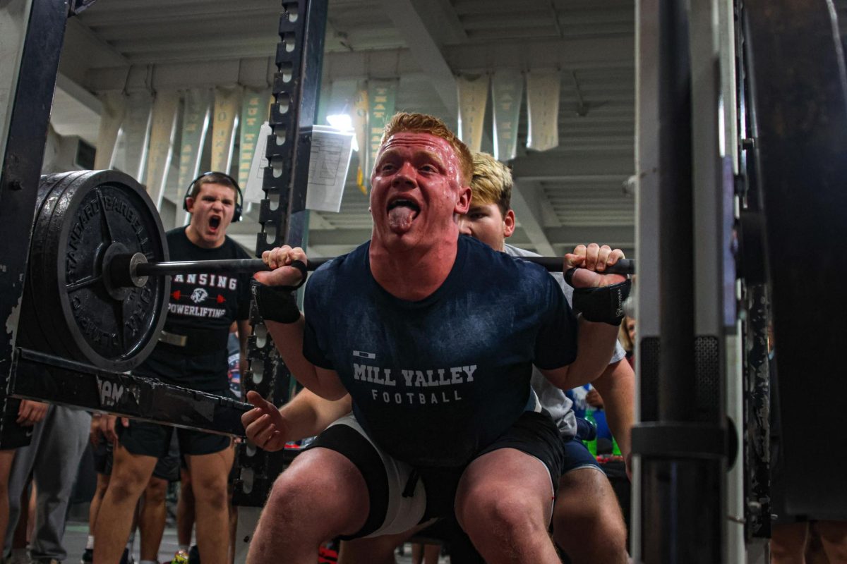 Spotted by a teammate, senior Waylon Schenk pushes himself to lift the weight. 