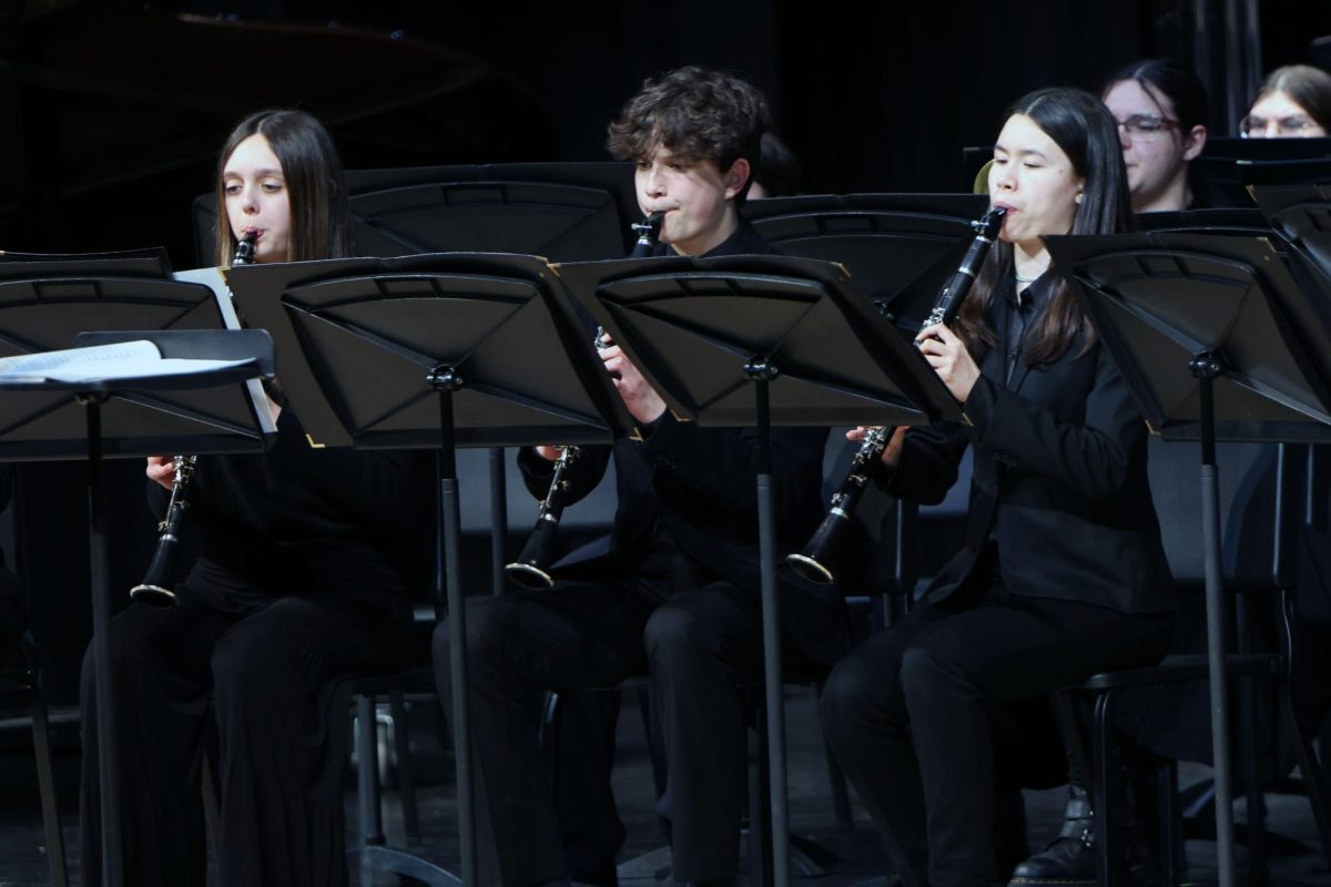 During the symphonic band performance, juniors Halle Nelson, Kai McGarry, and Sophie Hsu play the clarinet.