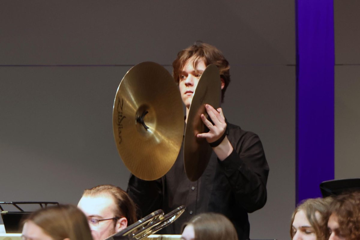 Looking to the side, junior Sawyer Clark plays the cymbals.