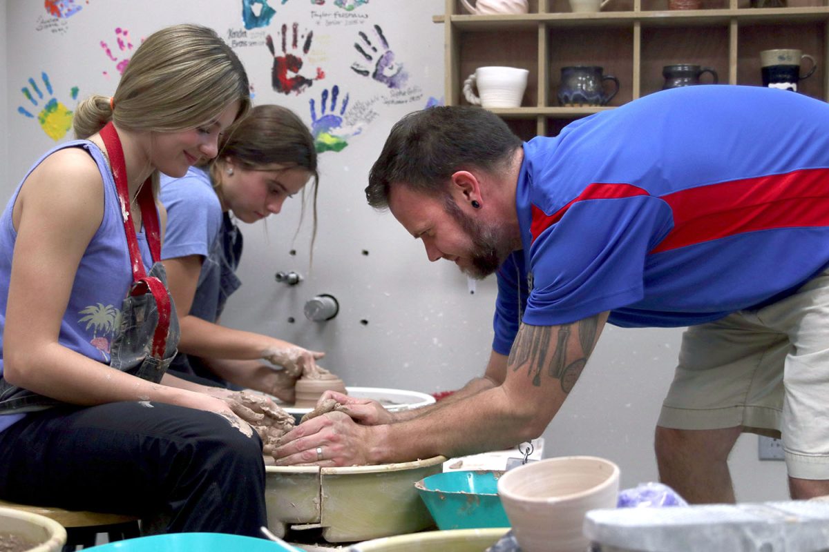 Assisting his student, art teacher Brian Lloyd shapes sophomore Savannah Seymours’ project Tuesday, Oct. 24. “I love having Mr. Lloyd as a teacher because he is great at teaching and making class fun,” Seymour said. “I would recommend the class to anyone because it lets you branch out and explore more ways to be creative.”