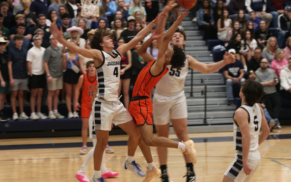 Jumping to block his opponent, sophomore Reece Riedel successfully overthrows his opponents attempted score.