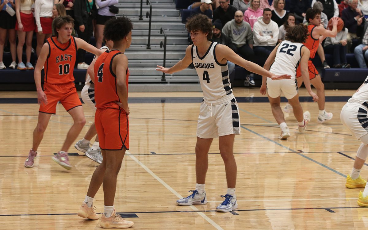 Blocking an opponent, sophomore Reece Riedel helps his team to victory.