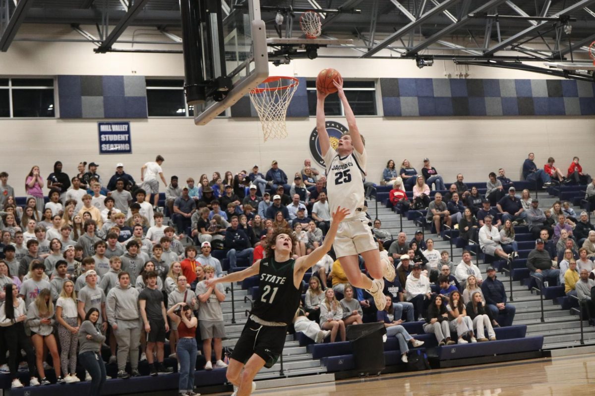 Jumping over his opponent, junior Carter Kaifes dunks the ball.