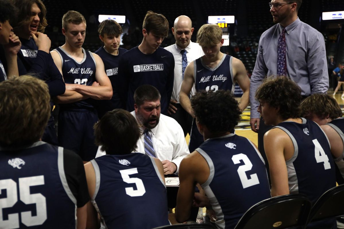 Listening to Coach Bangle, the team huddles together during a timeout.