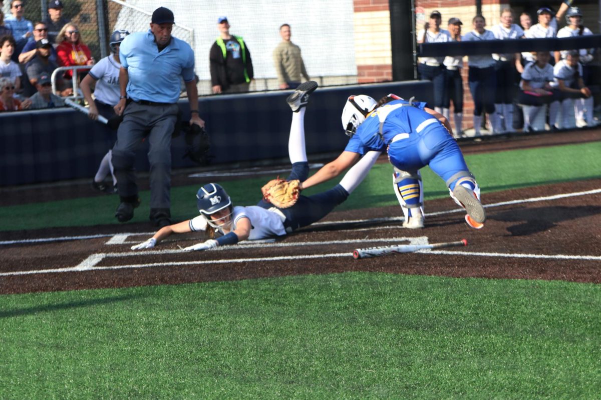 Evading her opponent, freshman Faith Pittenger slides into home plate.