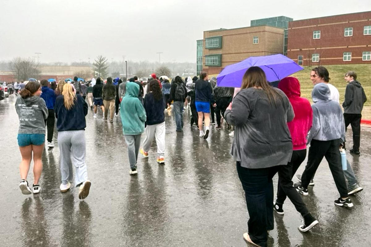 Beginning to move toward Monticello Trails Middle School, students and staff walk away from the school Thursday, March 7.