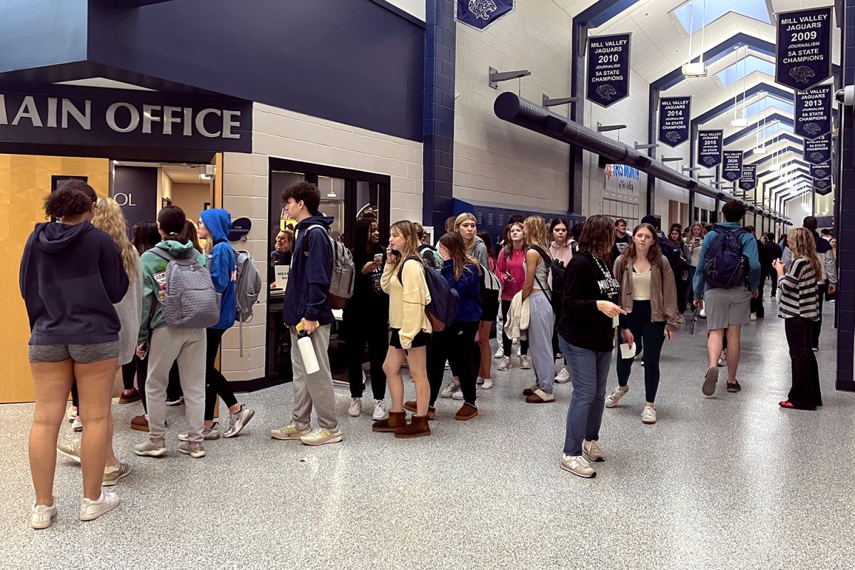 Trailing down C Hall in a line, students wait to go home and get changed out of their rain-soaked clothes.