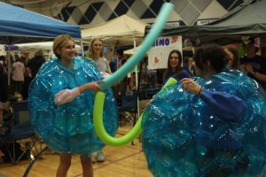 Sophomore Grace Holland and junior Miranda Hakes play the bubble battle game at the “Finding Nemo” station. 