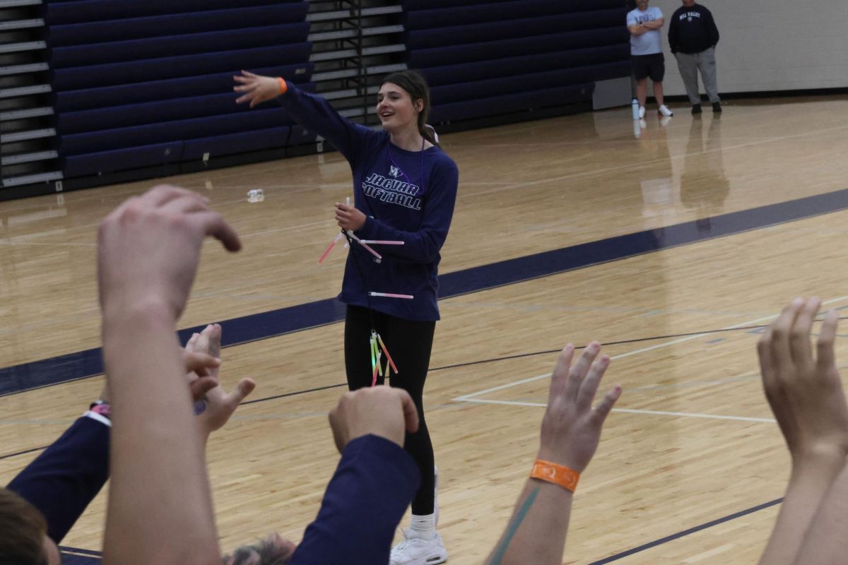 Freshman Faith Pittenger throws a glow stick to the crowd during the Fight Back Ceremony.