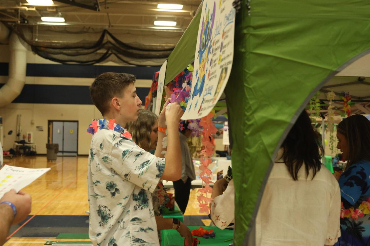 Freshman Bronson Moss decorates his “Lilo and Stitch” station before the public arrives. 