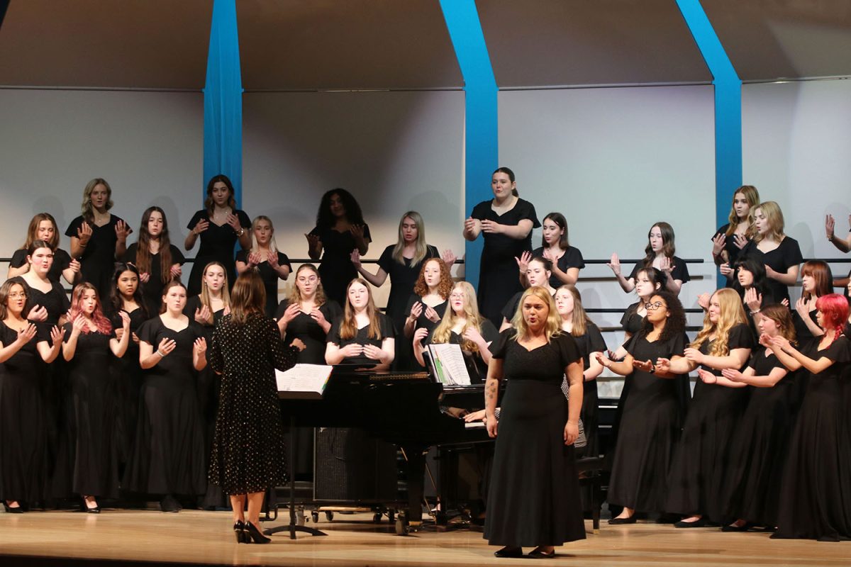 Moving their arms, the Treble choir all sing together. 