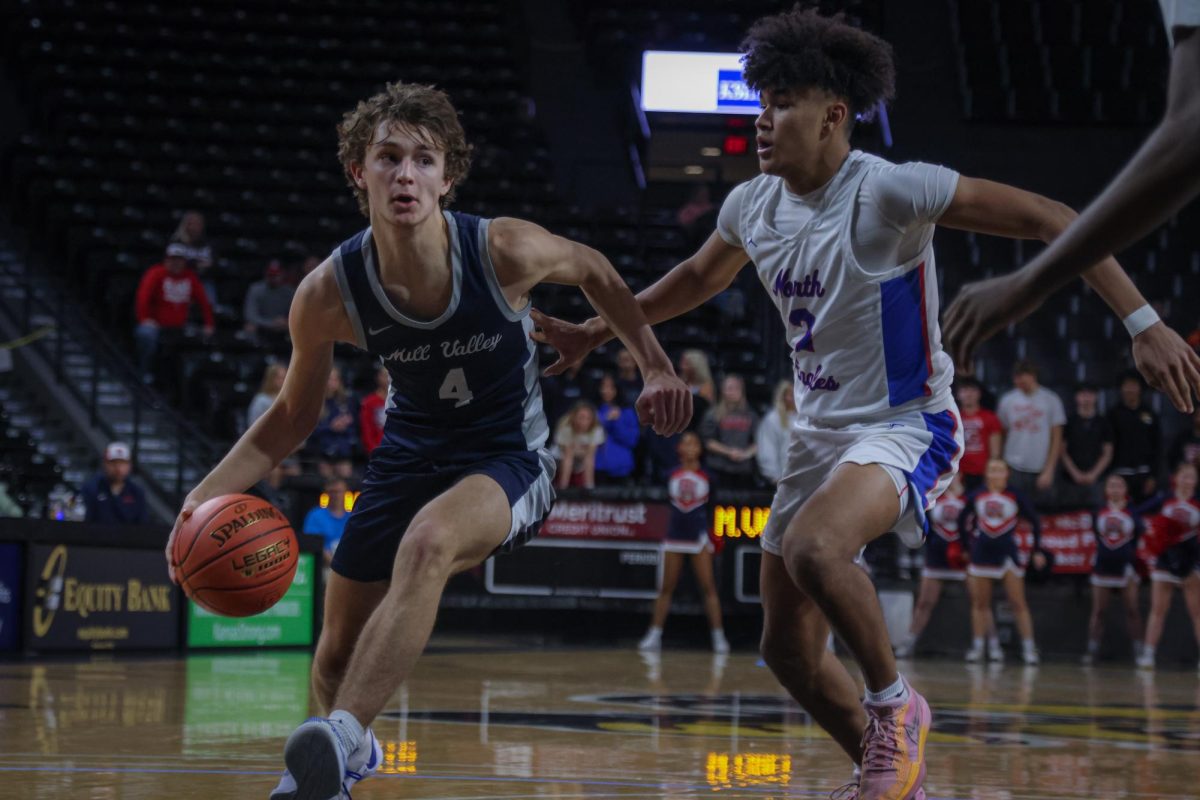 driving towards the basket, sophomore Reece Riedel evades the defender. 