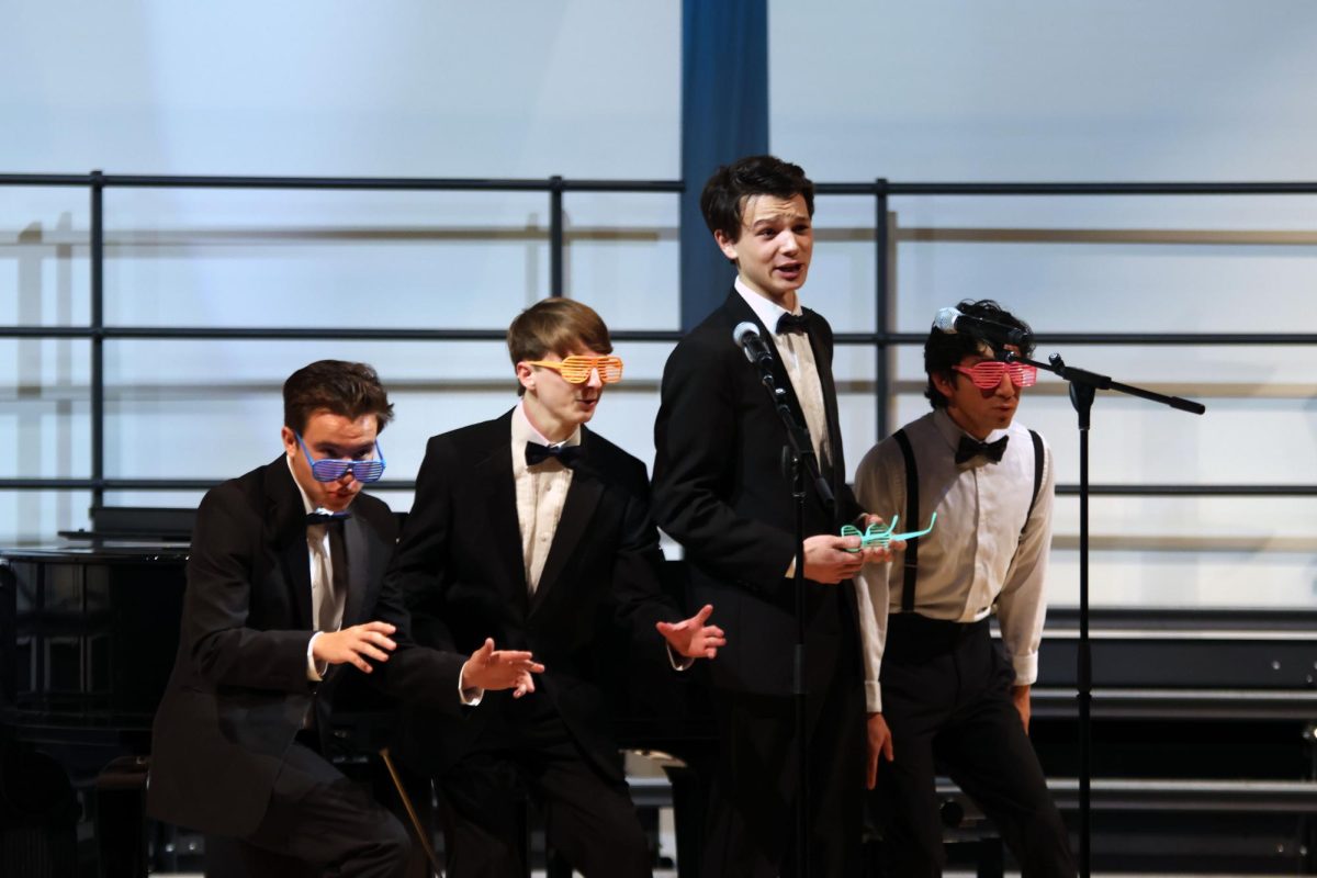 Taking his glasses off, junior Zane Lauer sings with the men's quartet consisting of senior AJ Lauer, sophomore Drew Cormany, and junior Yazid Vasquez
