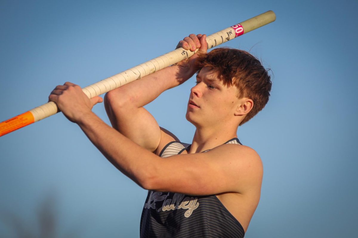 Holding his pole vault pole, senior Jackson Lawler prepares to jump. 