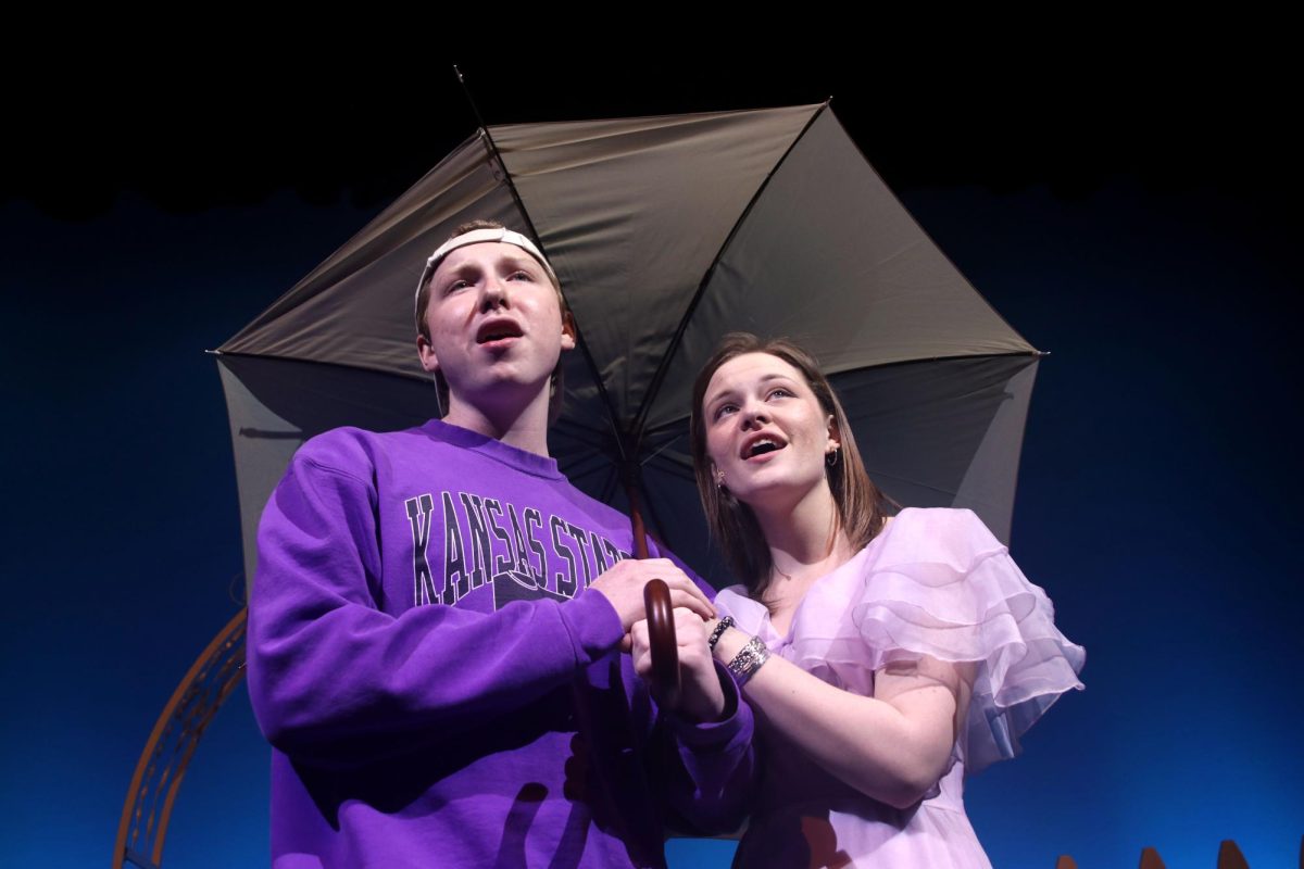 Junior Logan Koester and senior Caroline Alley sing the final notes of their duet under the shade of an umbrella.