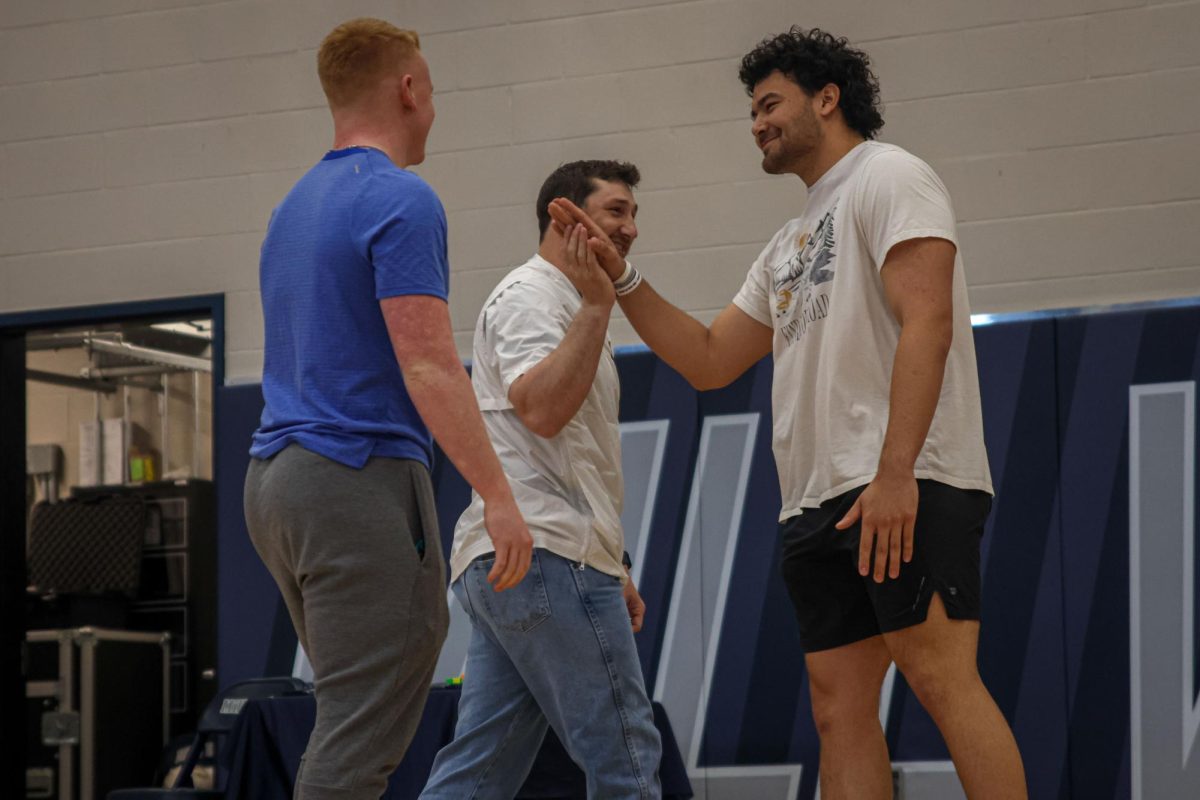 After announcing the powerlifting records, coach Sachen high fives senior Truman Griffith. 