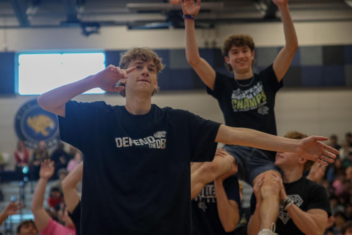 With his arms extended, senior Noah Brueggemann dances during the silver studs performance.   