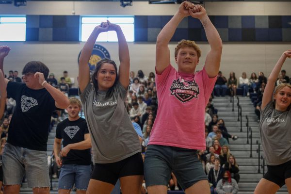 With their hands in the air, senior Macy Bidnick and junior Conner Wood bump hips. 