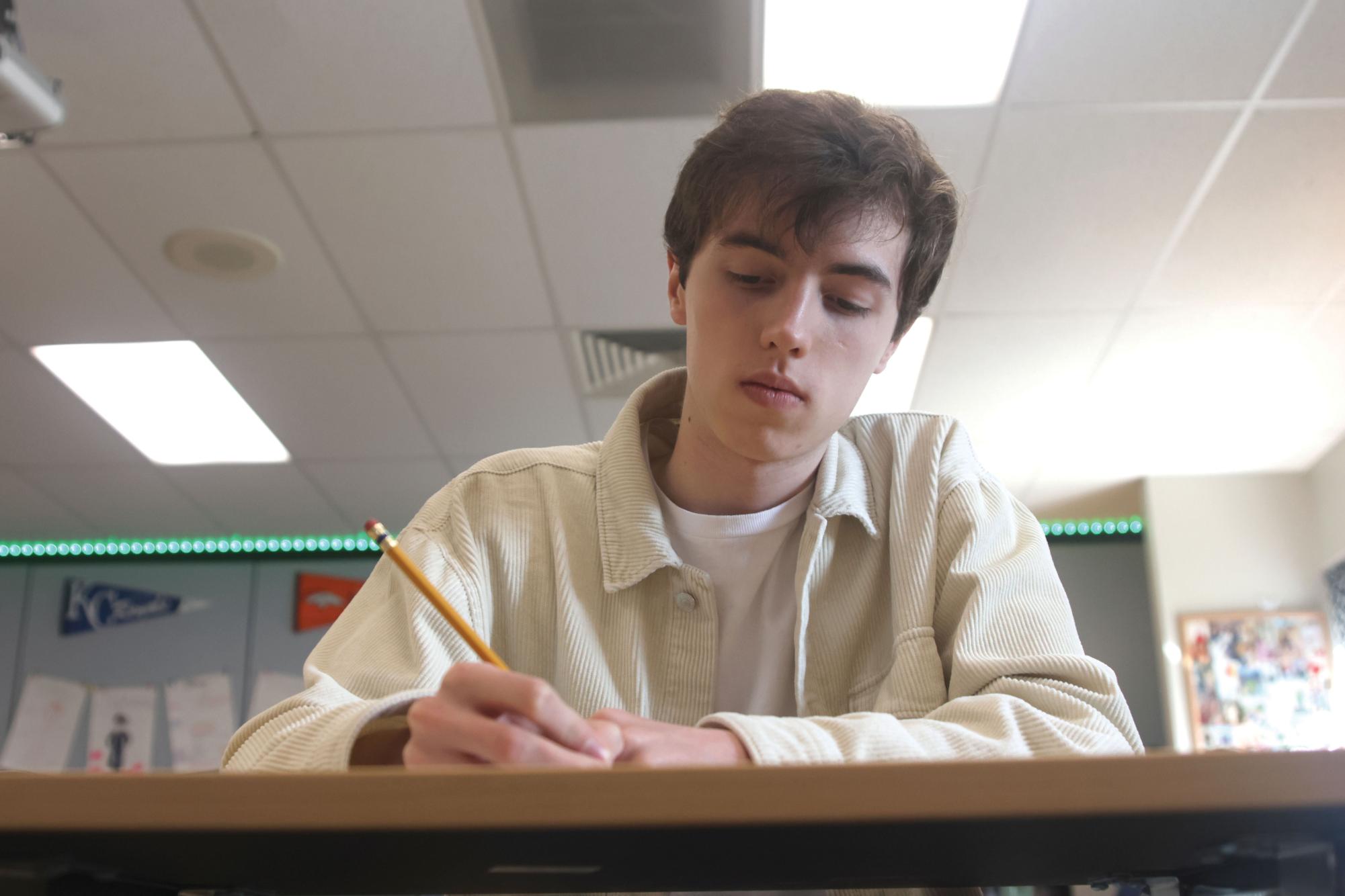 Writing during seminar Friday March 29, senior Nathan Anderson jots down ideas to use in future projects. Anderson found his passion for writing in his Creative Writing class this year, where he worked on some of the pieces he submitted.