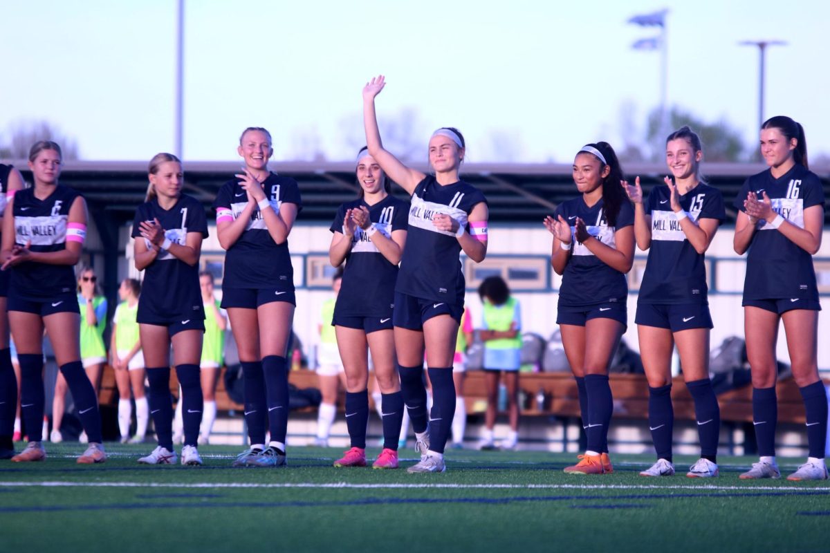 After being announced before the game, senior Kate Ricker waves to the crowd.