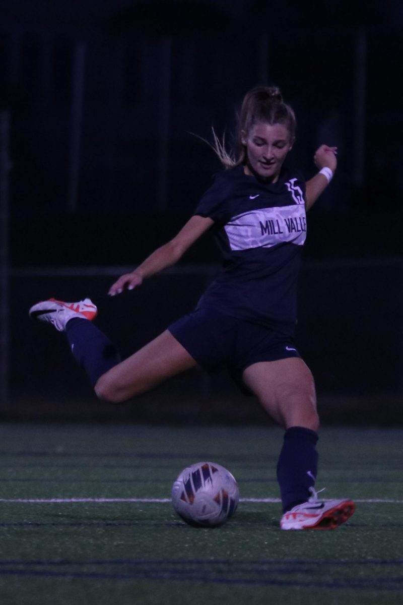 Leg in air, junior Kate Martin prepares to kick the ball.