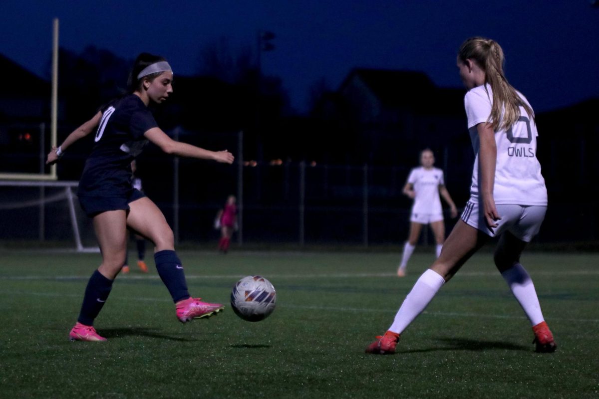 While playing offense, sophomore Ava Edwards kicks the ball away from her opponent.