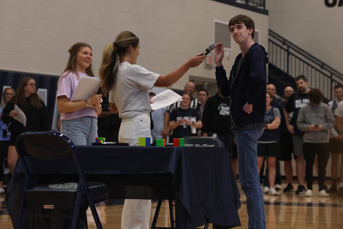 After winning the rubix cube competition against history teacher Jeff Wieland, junior Gabe Coleman waves to the crowd.