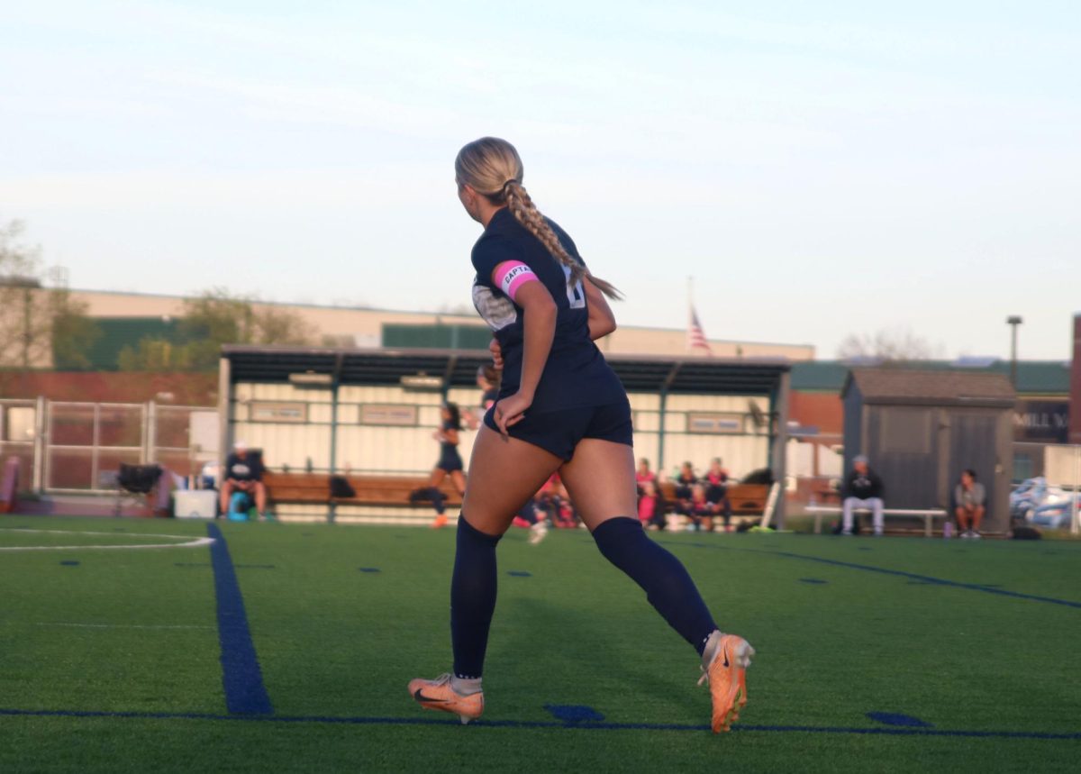 Getting ready to play against Olathe West, senior Brooke Bellehumeur runs across the field