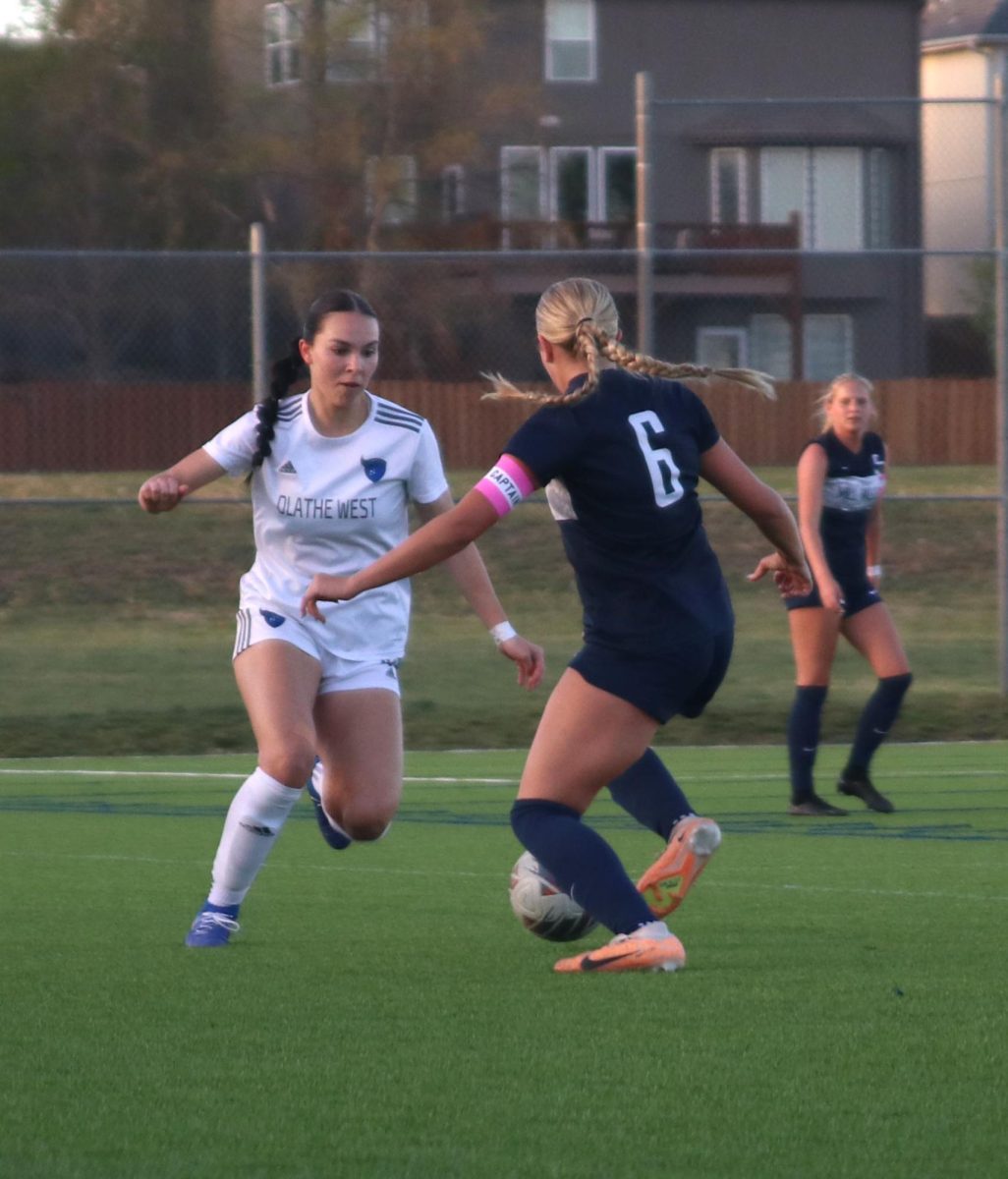 Dribbling the Ball across the field, junior Brooke Bellehumeur comes in contact with Olathe West