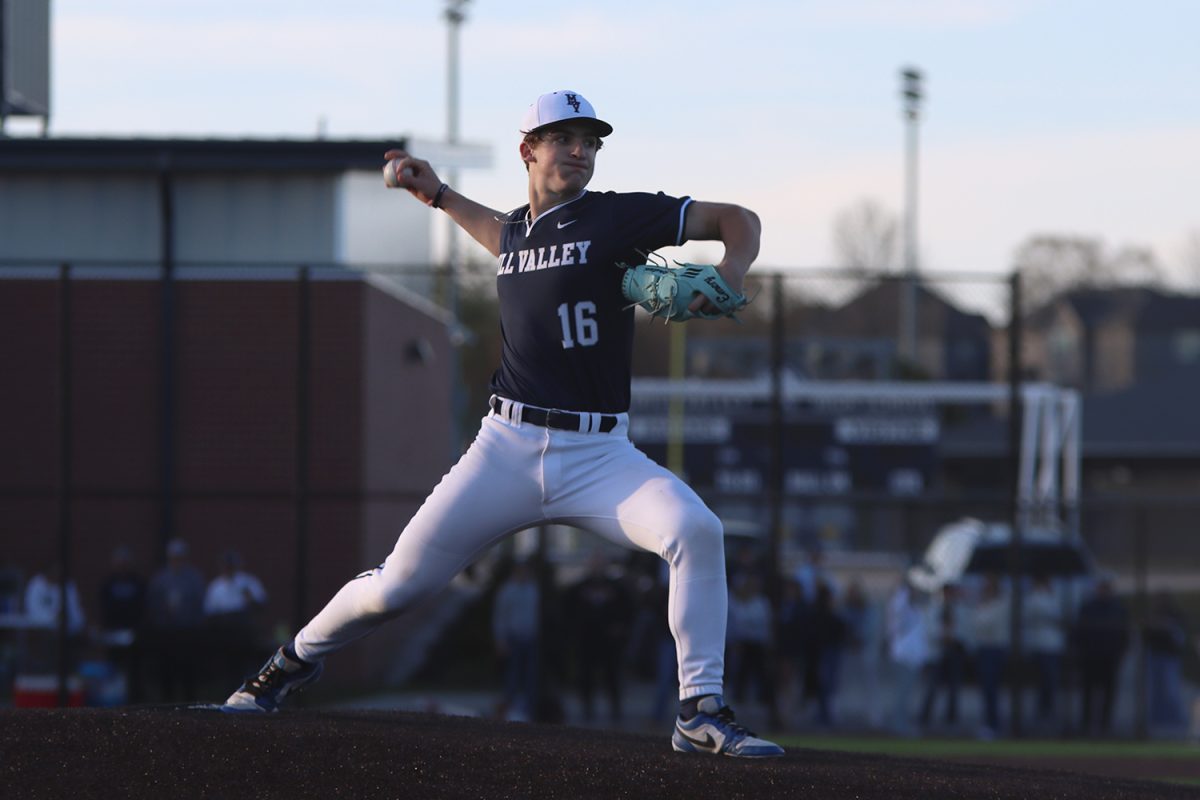 Stretching out, sophomore Beau Peterson throws a pitch to the hitter.