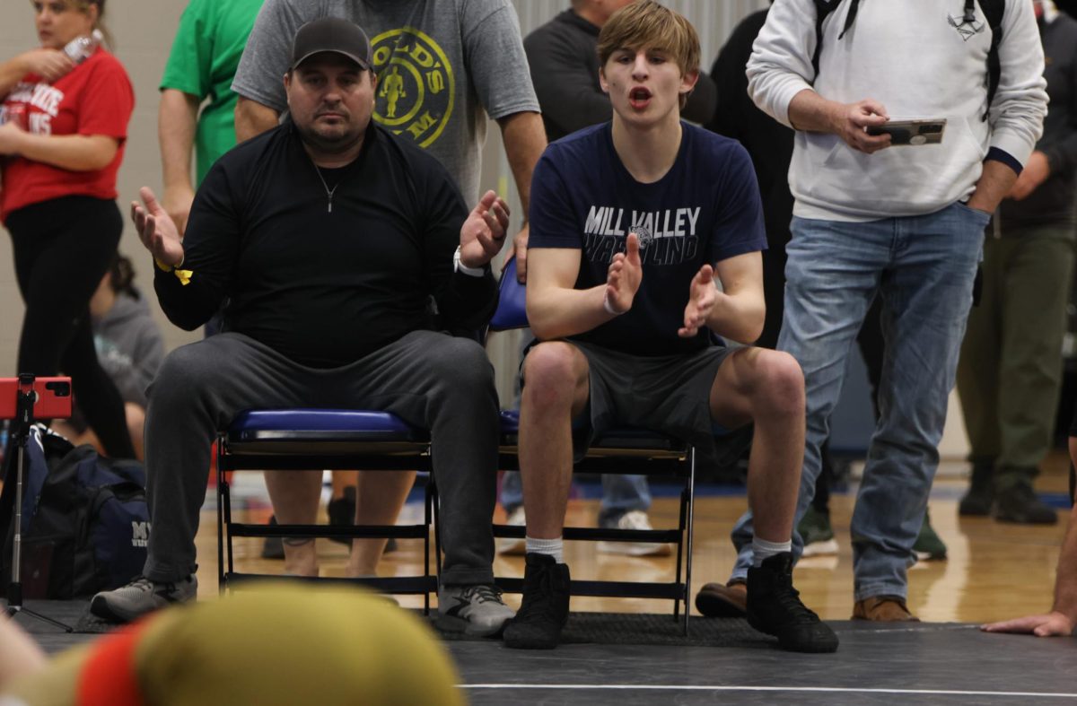 Clapping, senior Colin McAlister cheers on  his wrestler for getting the most points in the match on Saturday, April 6.