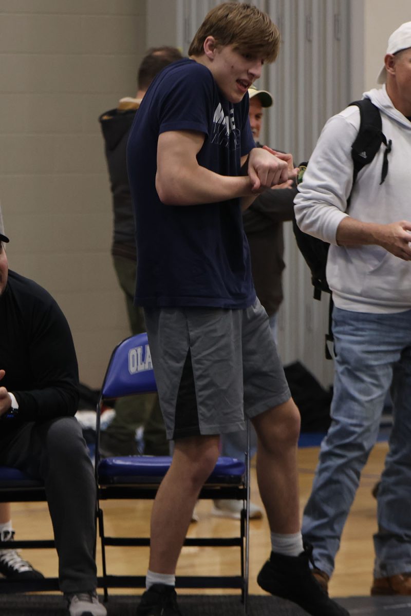 Coaching his wrestler, senior Colin McAlister tries to demonstrate a move that could be used in the next round Saturday, April 6.