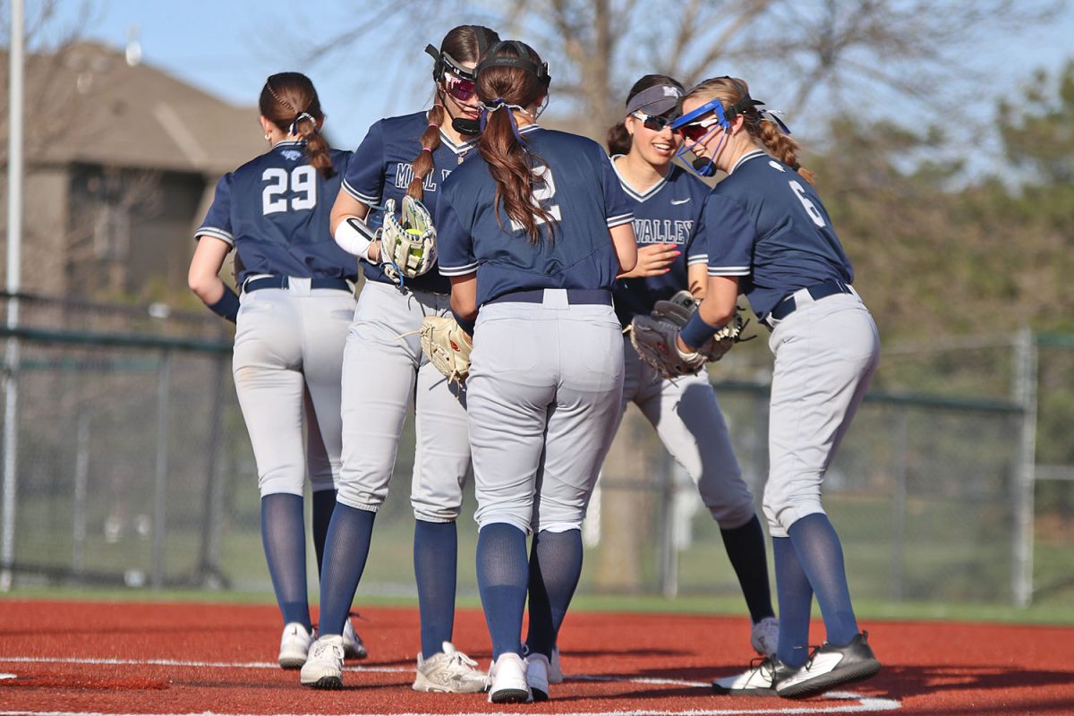 The team congratulates their pitcher, freshman Emma Hadley, in the circle after she struck out a batter.