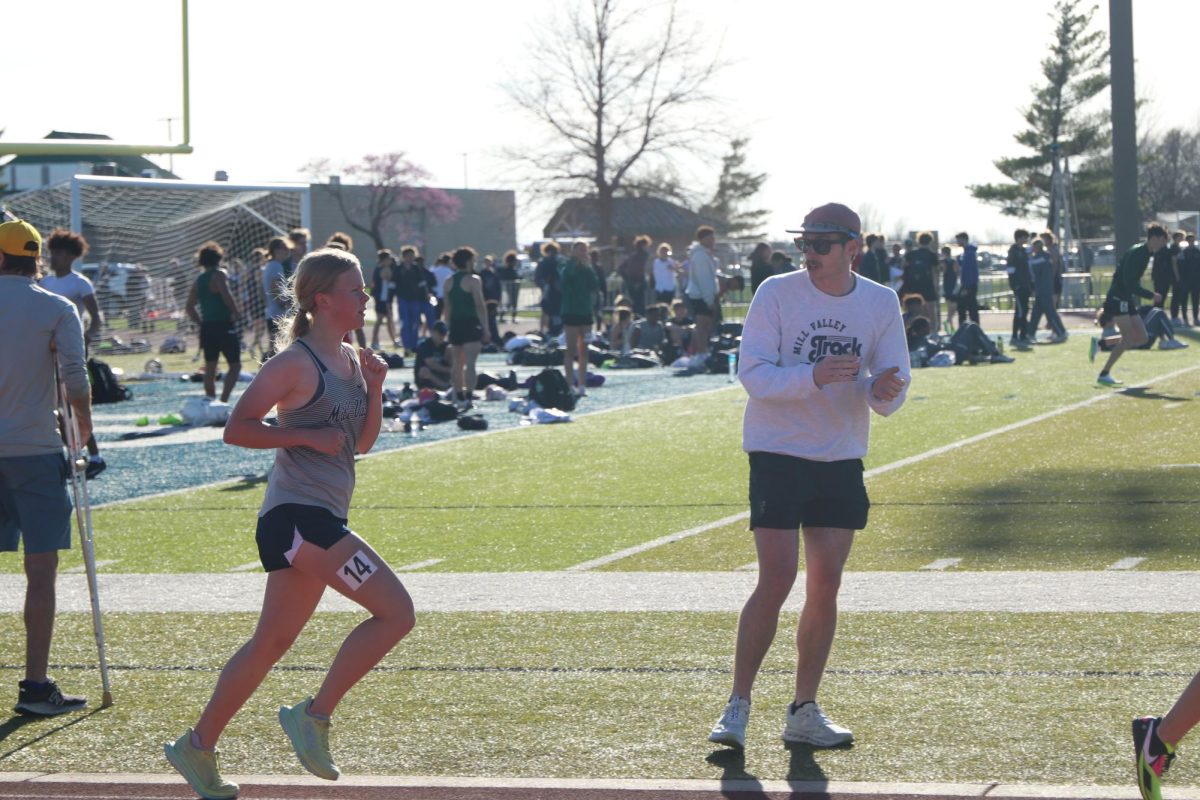 While being cheered on by assistant coach Brian Fitzsimmons, junior Sierra Manning focuses on finding her pace in the 1600 meter race.