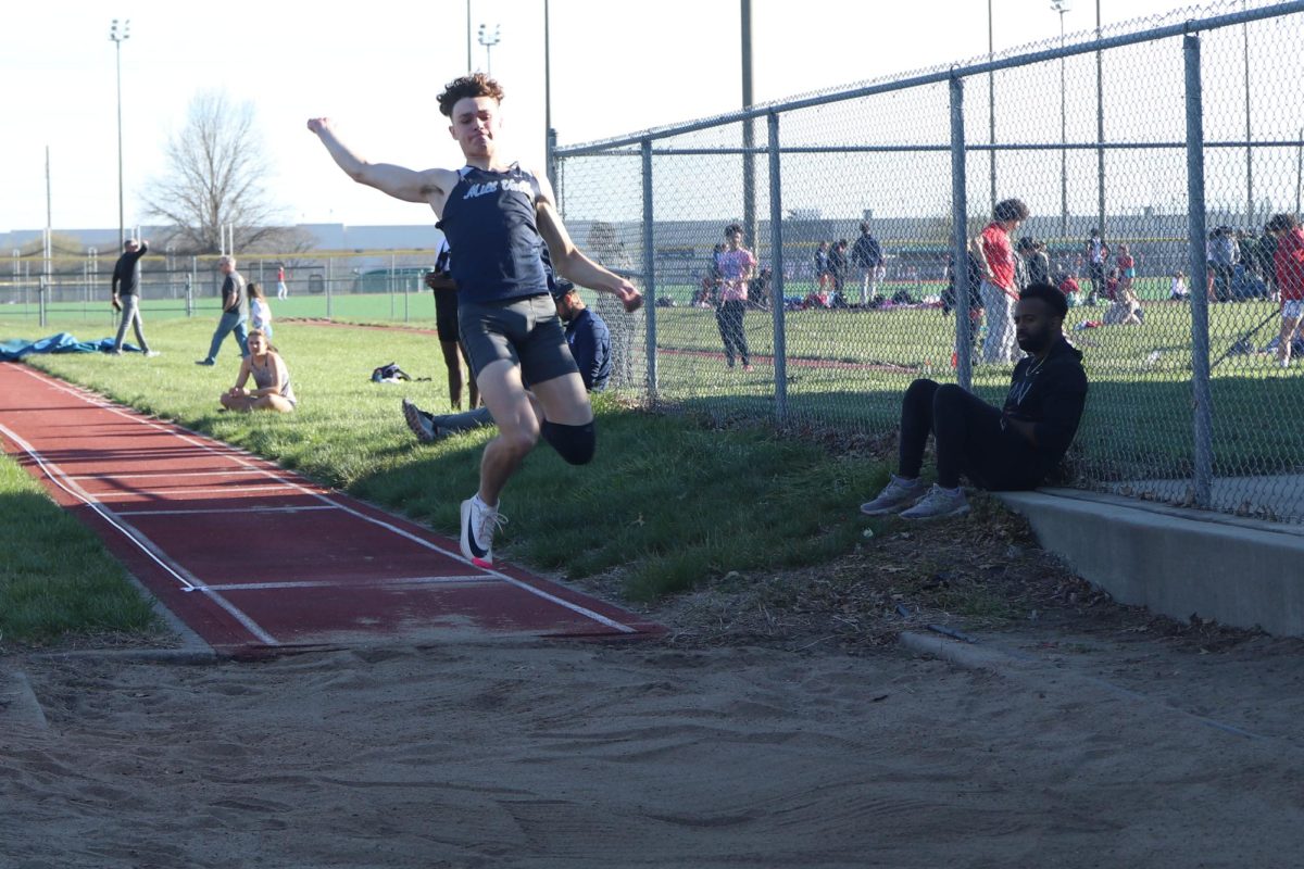 With his eyes on the sand in front of him, senior Gage Graham competes in the long jump.